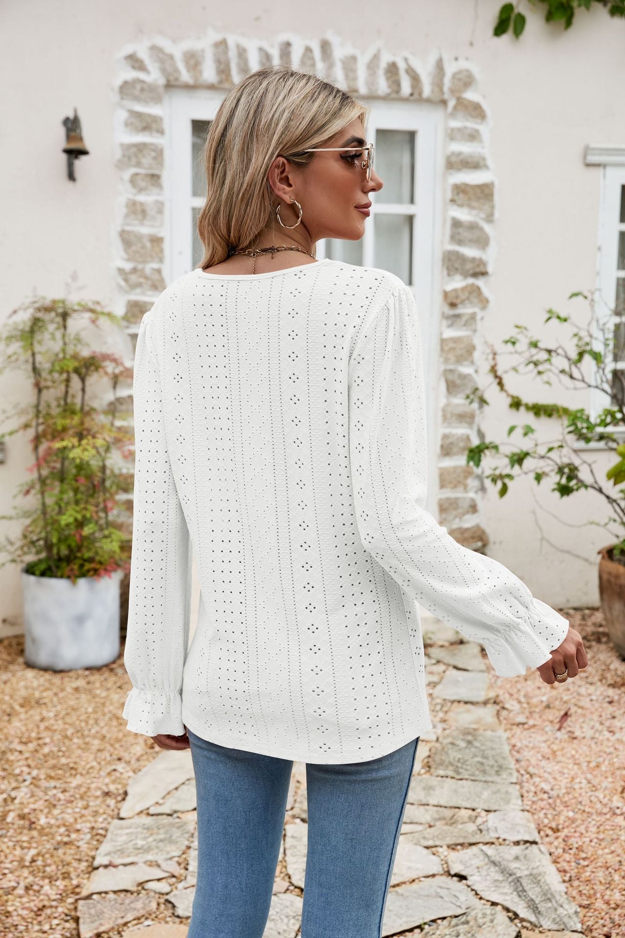 White eyelet lace blouse with ruffle cuffs and long sleeves.