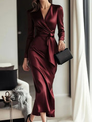 Burgundy satin maternity wrap dress with tie waist and long sleeves.