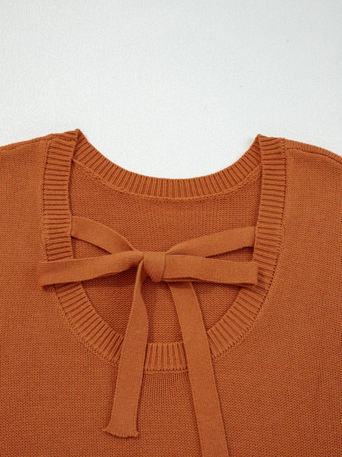 Caramel acrylic blend sweater with a tie bow detail at the back neckline.