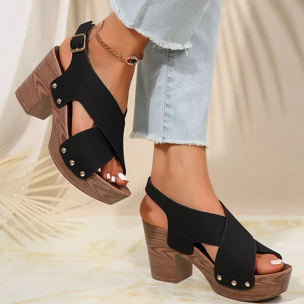 Black crisscross high heel sandals with stud details and adjustable ankle strap.
