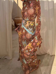 Brown celestial print maxi dress with a scarf belt and bell sleeves.