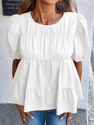 White maternity blouse with puff sleeves, tiered ruffle hem, and smocked bodice detail.