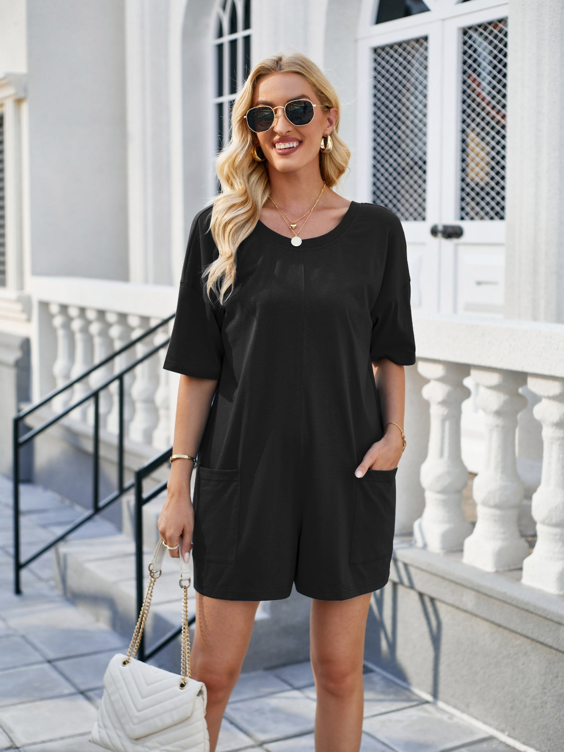 Black relaxed backless tee romper with pockets and short sleeves