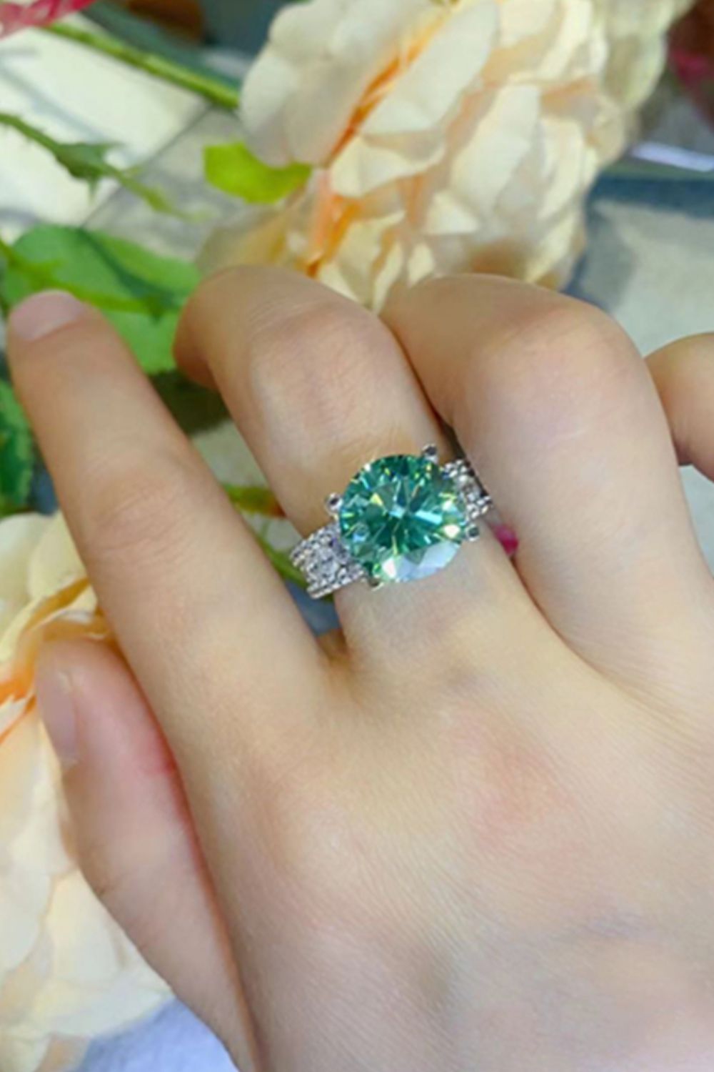 Light green moissanite pavé band ring with a large center stone.