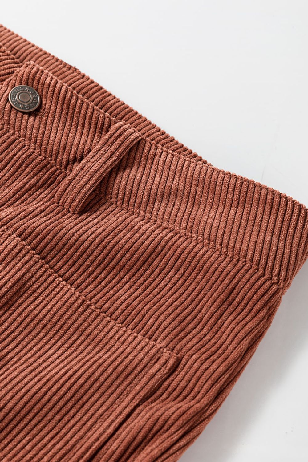 Brown corduroy flared leg trousers with visible stitching and button detail.