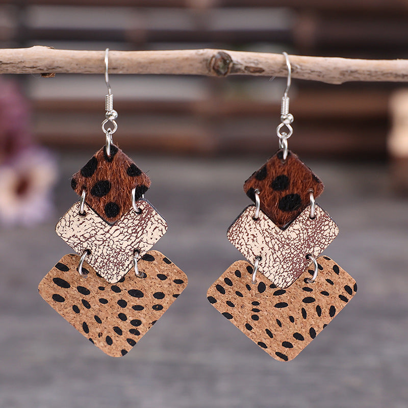 Textured leopard print drop earrings in tan and dark brown with layered diamond shapes.
