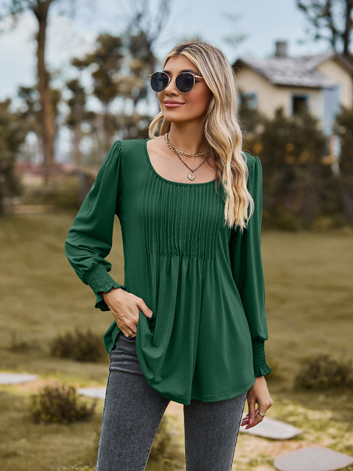 Green peplum blouse with gathered yoke and smocked cuffs
