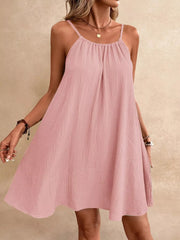 Dusty pink spaghetti strap mini dress with gathered neckline and textured fabric.