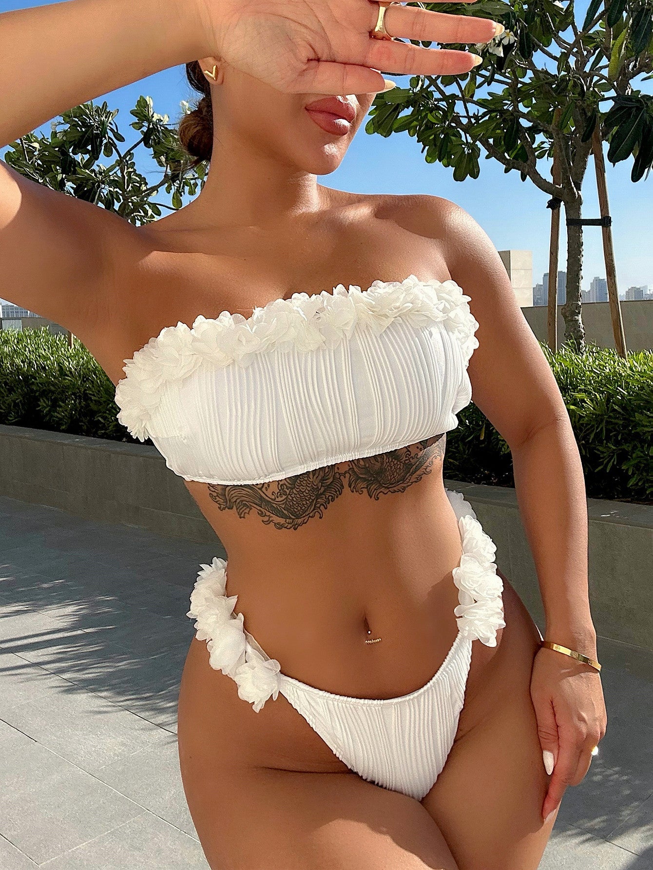 Textured white bandeau bikini set with ruffle trim and ruched fabric.