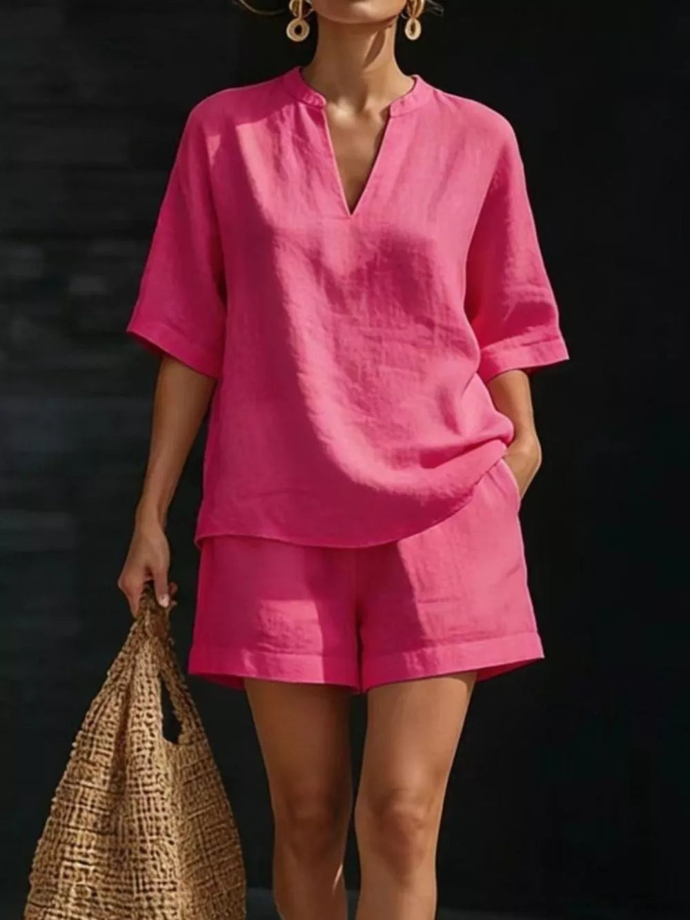 Fuchsia pink oversized two-piece set with V-neck top and shorts.