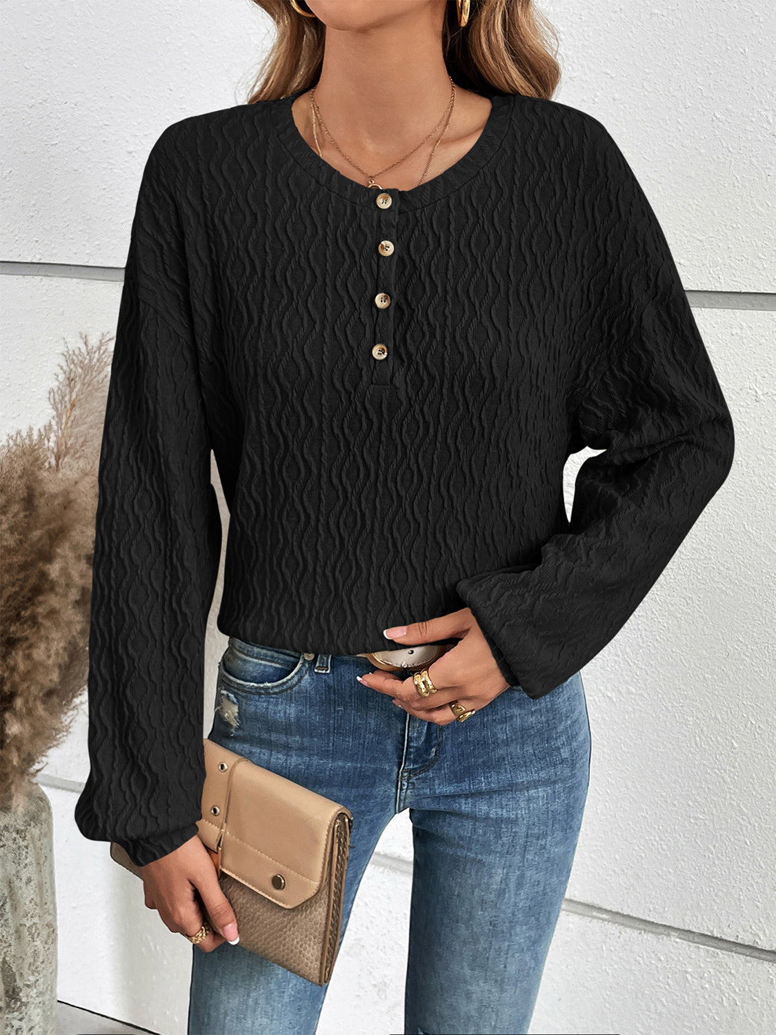 Black textured henley blouse with button detail and blouson sleeves.