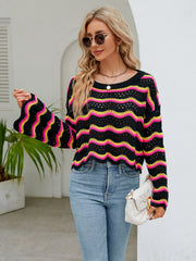 Black crochet crop sweater with pink and yellow wavy stripes, bell sleeves.