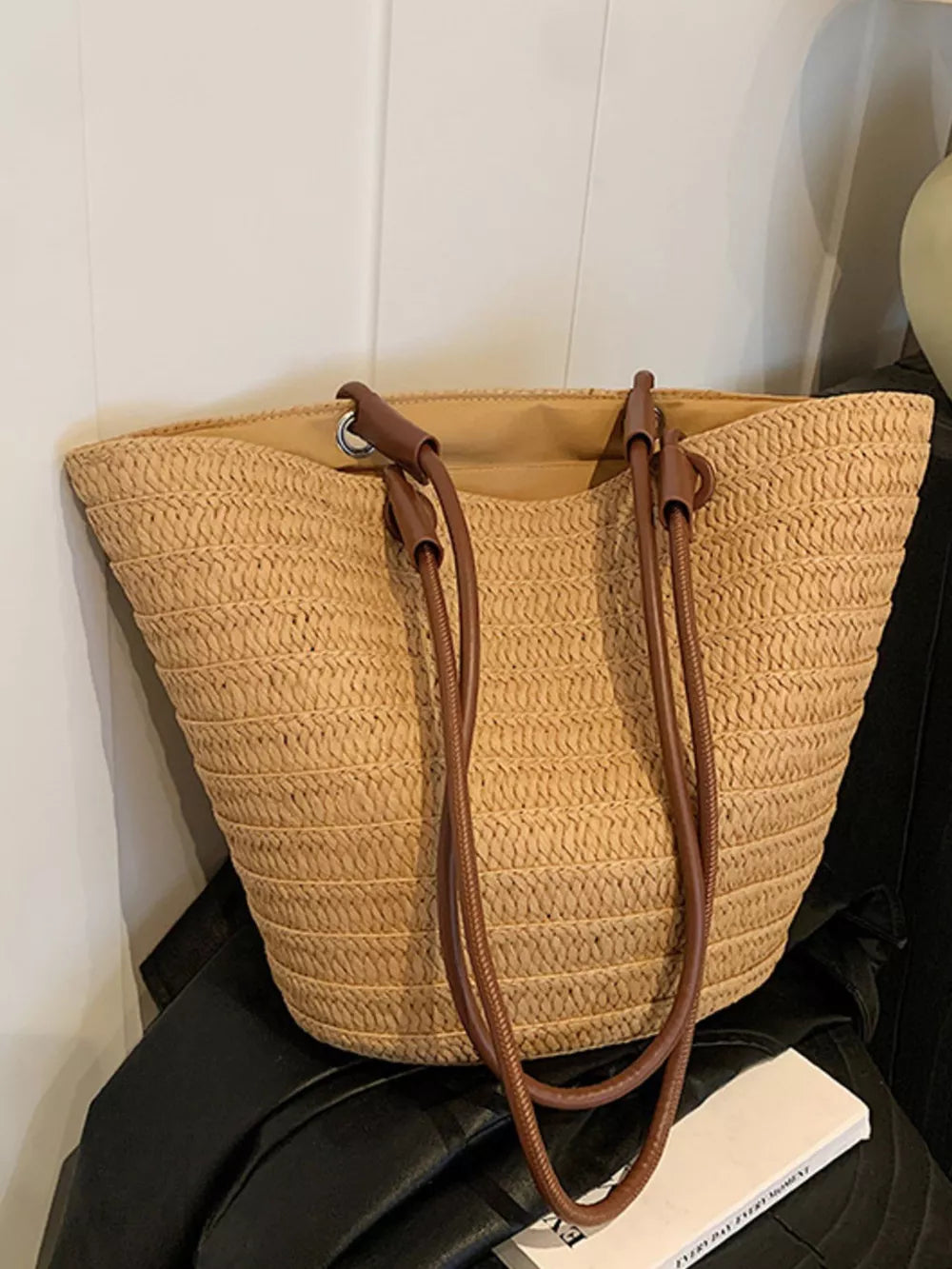Natural straw woven large shoulder bag with brown leather straps.