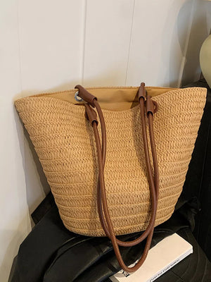 Natural straw woven large shoulder bag with brown leather straps.