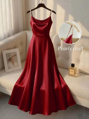 Burgundy satin cami dress with pearl-embellished straps and a draped neckline.