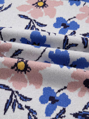 Patchwork sweater with a floral design in pink and blue on a white knit background.