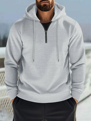 Gray waffle-knit quarter-zip hooded pullover with drawstring and black undershirt.