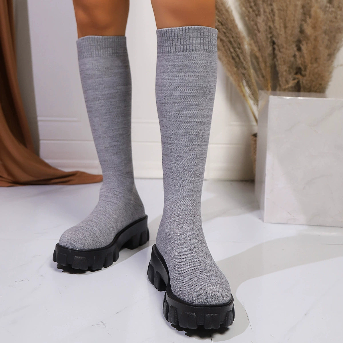 Gray knit knee-high boots with chunky platform soles.