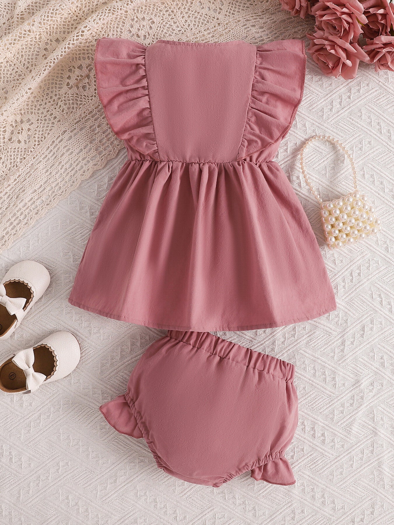 Pink baby set with ruffled sleeves and bloomers, featuring button front detail.