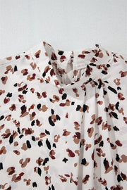 White high-neck blouse with abstract print and pleat detail