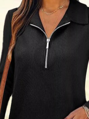 Black ribbed knit half-zip top with a collar and silver zipper detail.