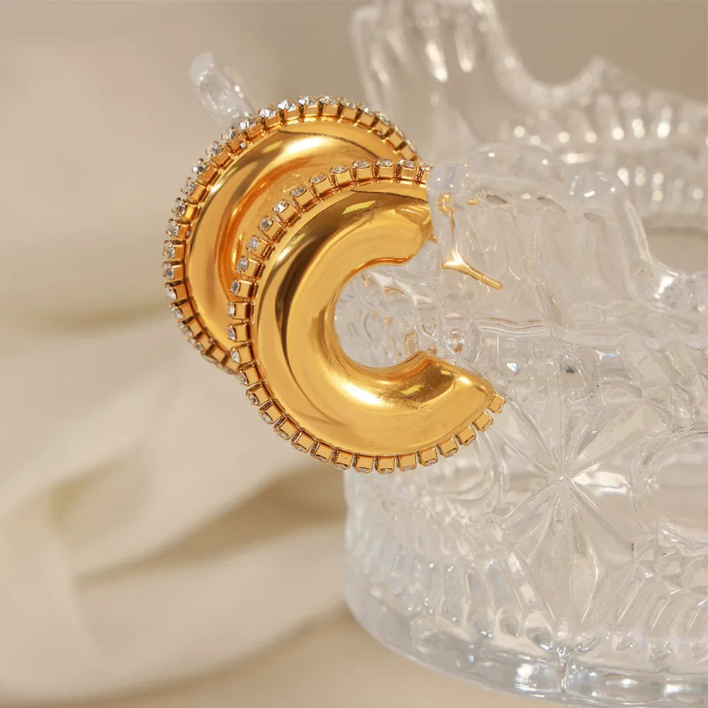 Gold cubic zirconia embellished crescent hoop earrings with a polished finish.