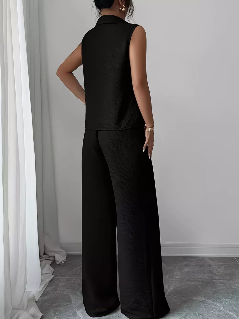 Black sleeveless collared top and wide-leg pants set with textured fabric.