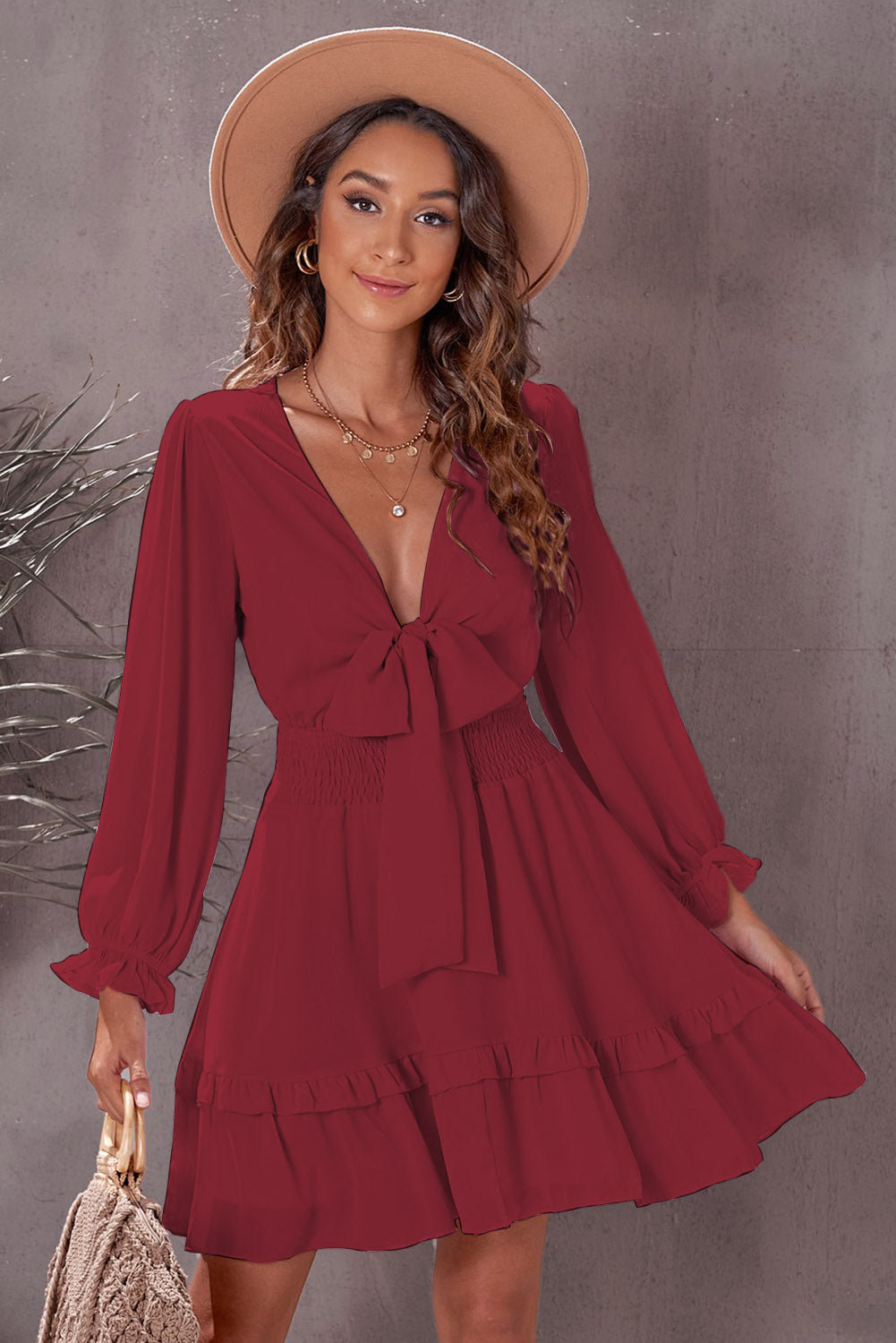 Wine ruffled mini dress with bow-tie waist, smocked bodice, and long sleeves.