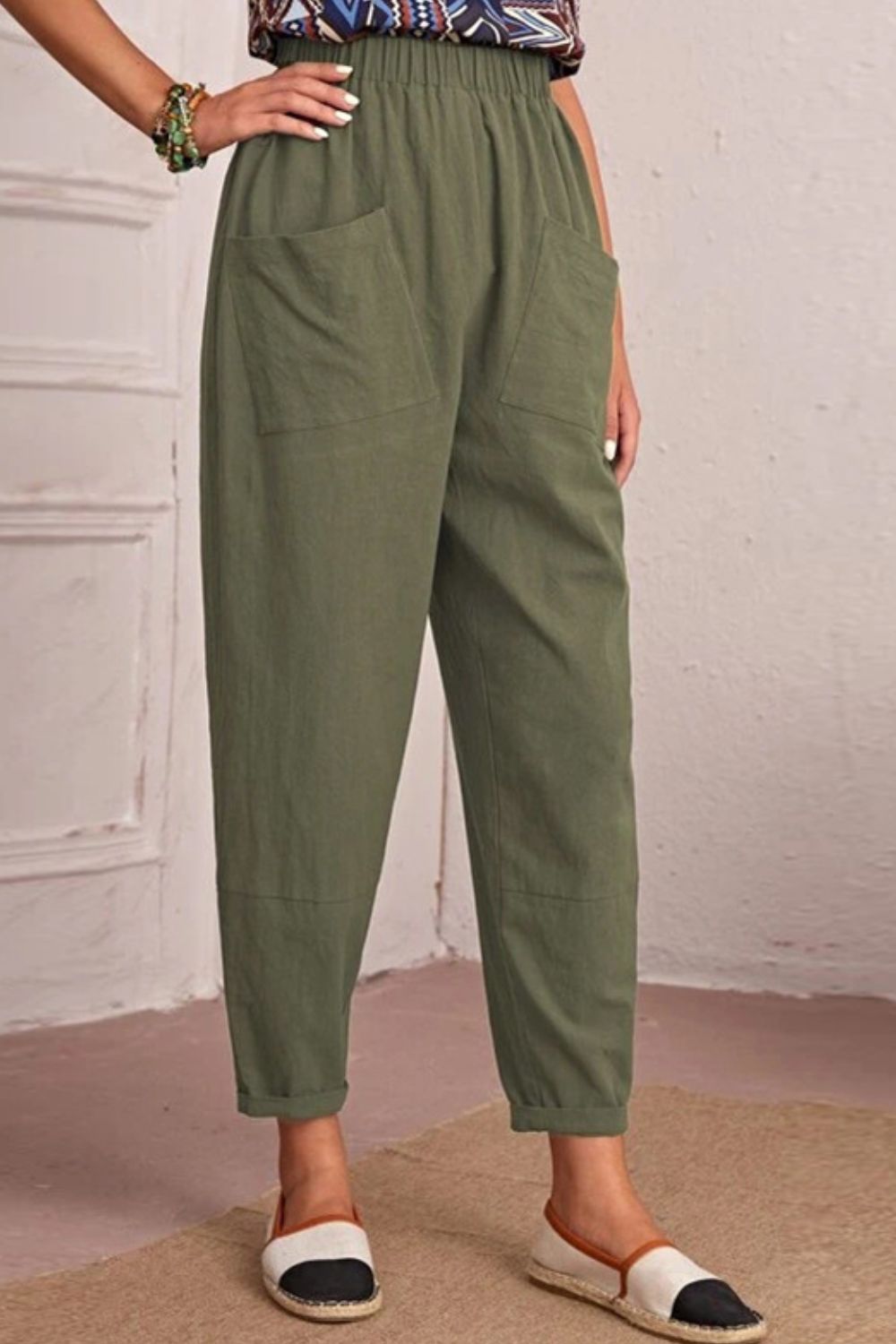 Matcha green linen tapered trousers with elastic waist and large front pockets.