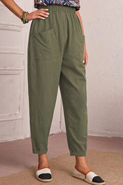 Matcha green linen tapered trousers with elastic waist and large front pockets.