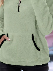 Light green fleece quarter zip pullover with black trim on pocket and zipper.