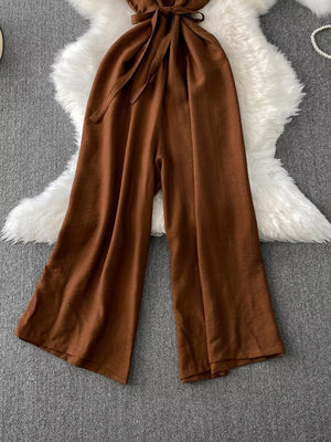 Brown V-neck wide leg jumpsuit with tie waist and button details