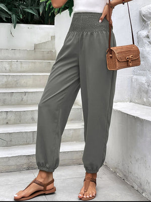 Gray smocked waistline relaxed-fit trousers with cinched ankles.