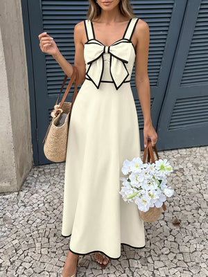 Elegant A-line midi dress in beige with black trim and a large bow detail on the bust.