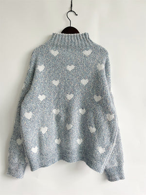 Mint blue acrylic turtleneck sweater with allover white heart motif and textured knit.