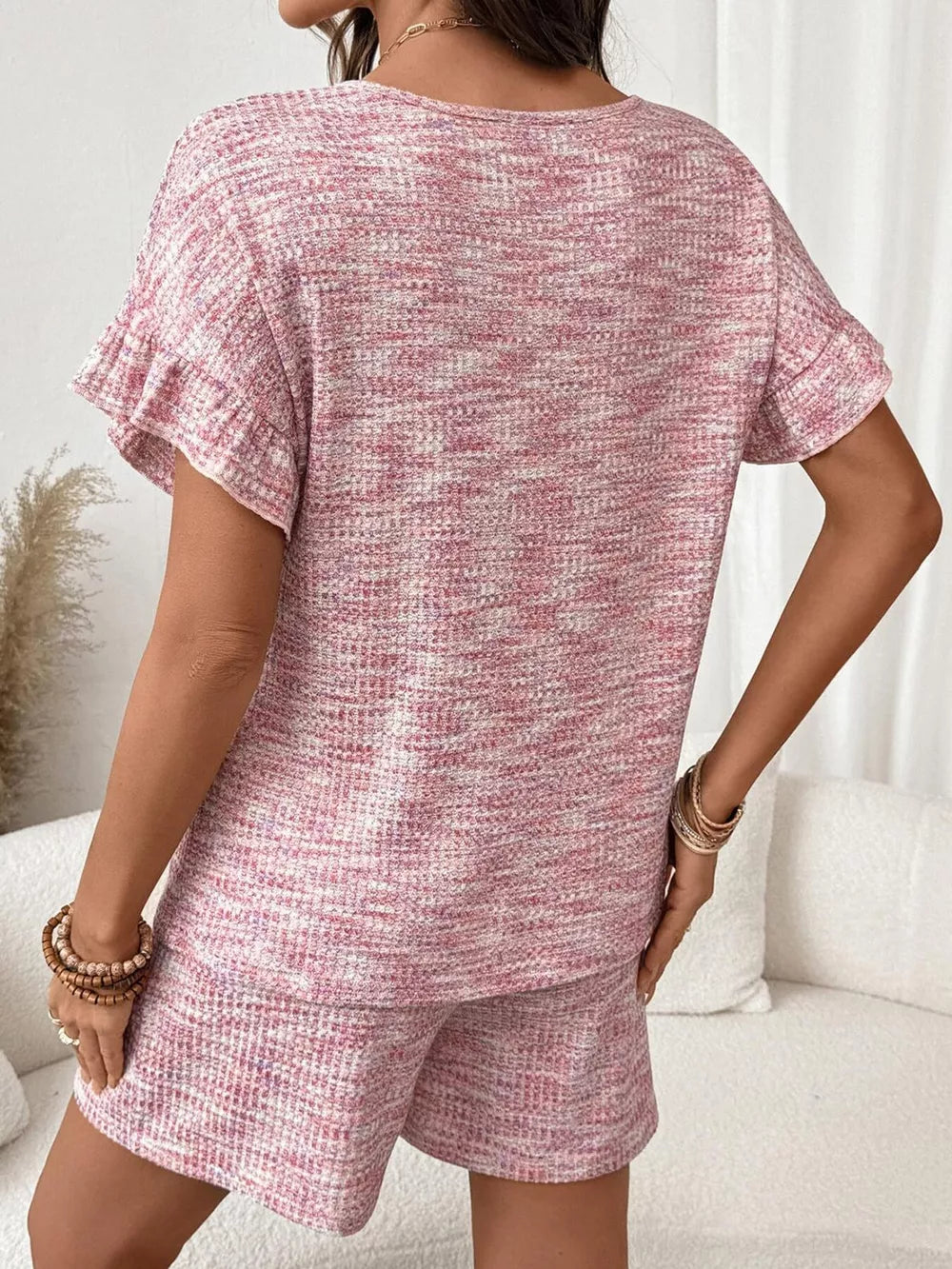 Pink ruffled sleeve two-piece set with textured shorts and top.
