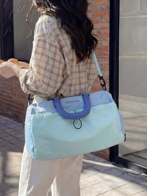 Light blue and mint green Oxford cloth travel bag with blue handles and strap.
