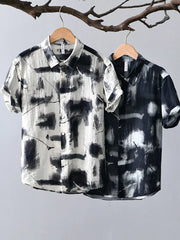 Men's short sleeve button-down shirt in black and white abstract print.