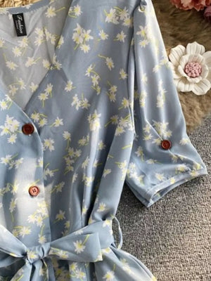 Light blue floral V-neck midi dress with button-down front and belted waist.