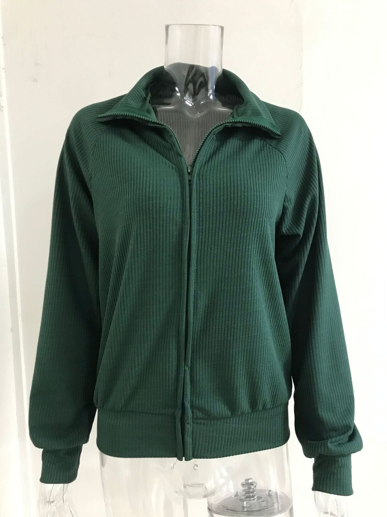 Green ribbed knit zip-up jacket with collar and long sleeves.