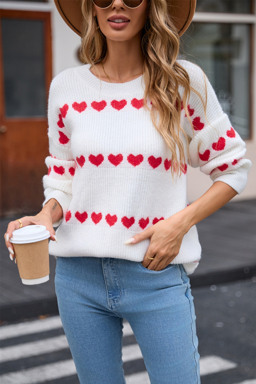 White knit pullover sweater with red heart stripe pattern and crew neck.