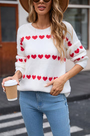 White knit pullover sweater with red heart stripe pattern and crew neck.