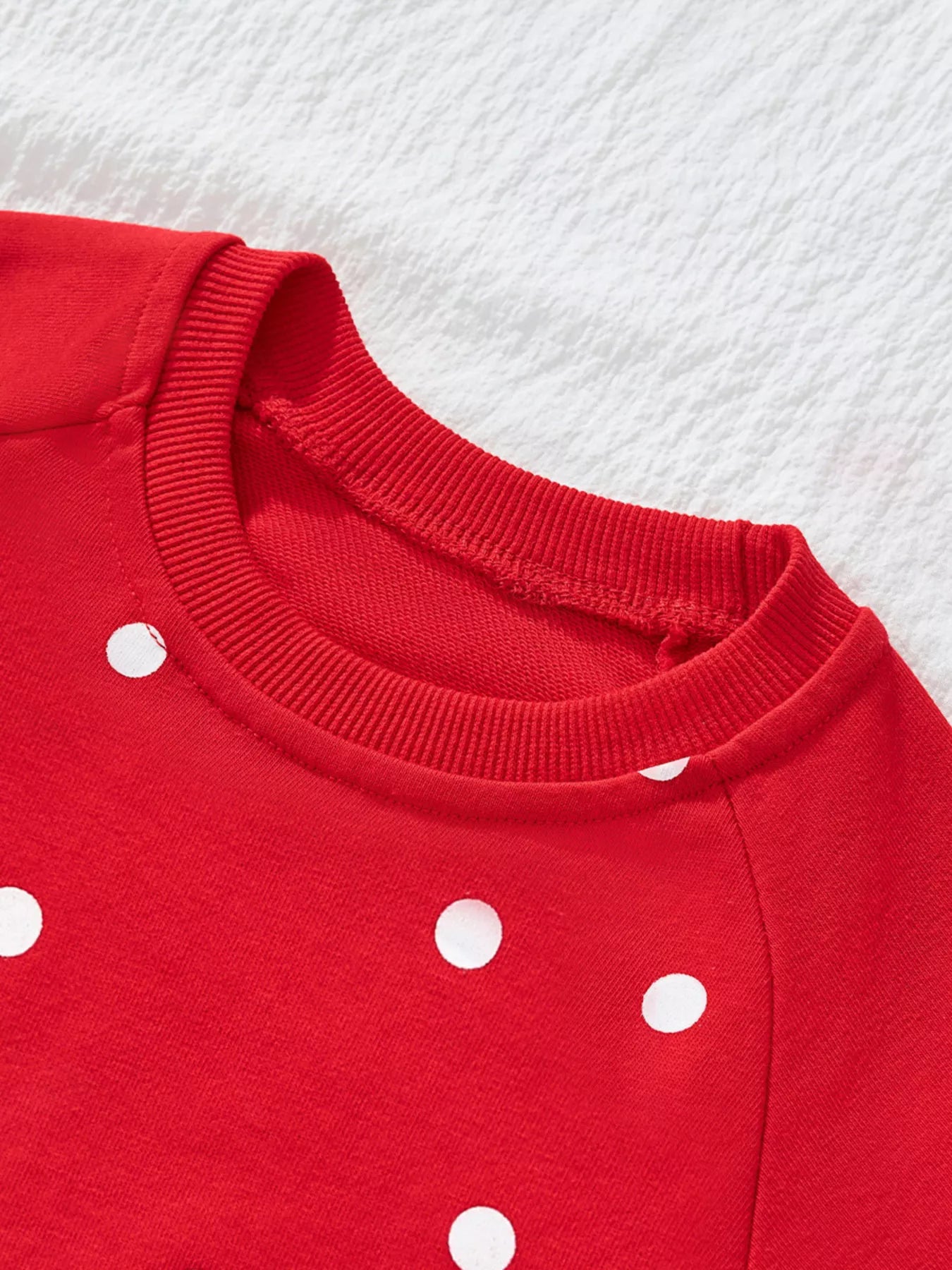Red polka dot sweatshirt with crewneck and ribbed cuffs.
