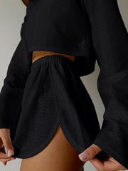 Black perforated crop top and shorts set with elastic waist and side slit shorts.