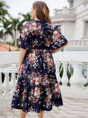 Navy floral midi dress with flutter sleeves and tiered ruffle hem.