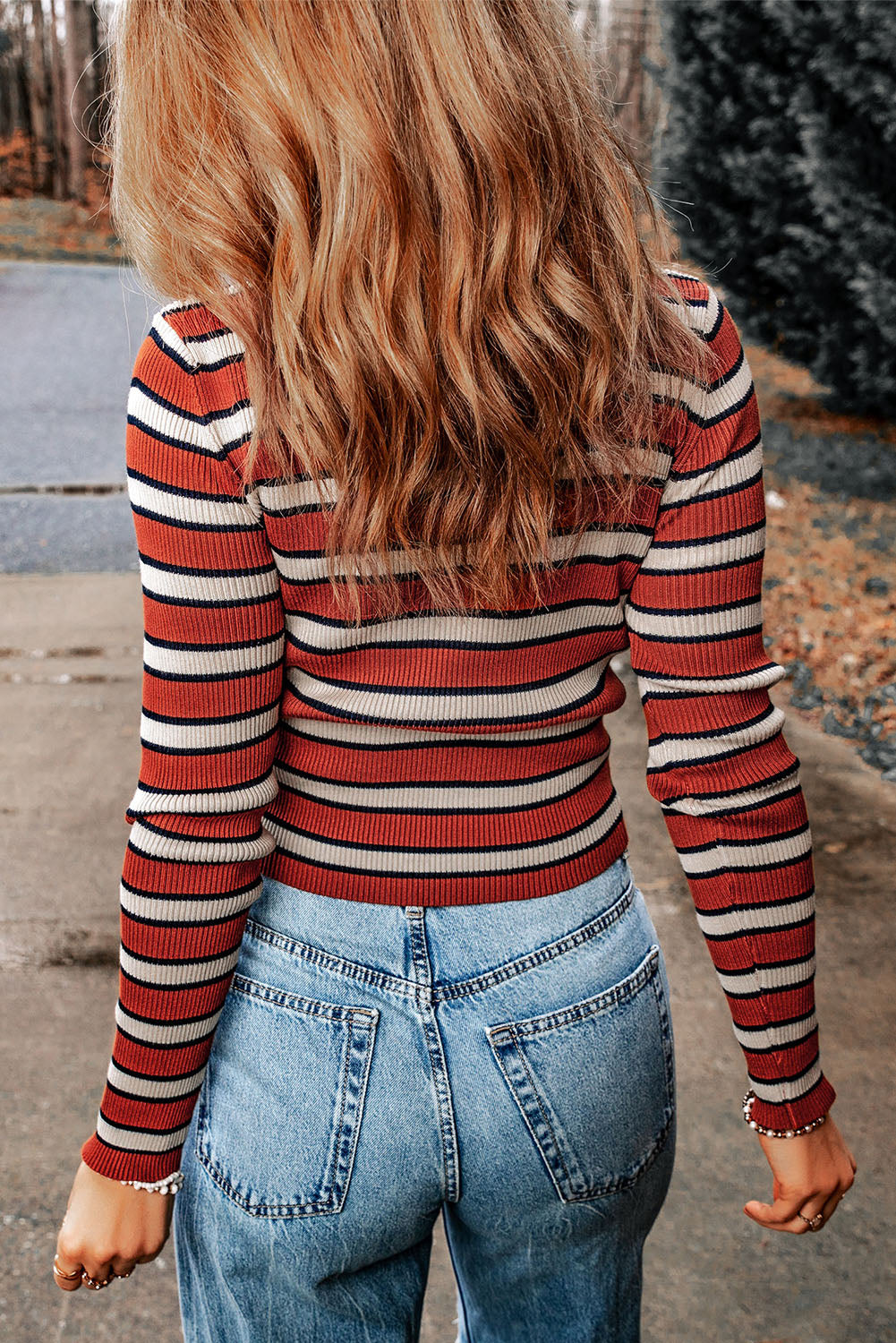 Ribbed stripe knit crewneck sweater with red, cream, and navy stripes.