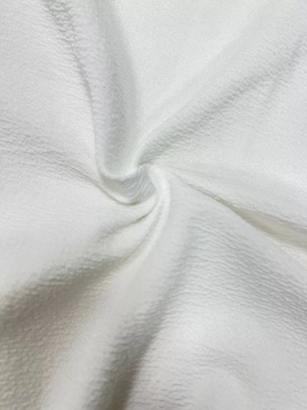 White textured fabric detail of a longline vest coat