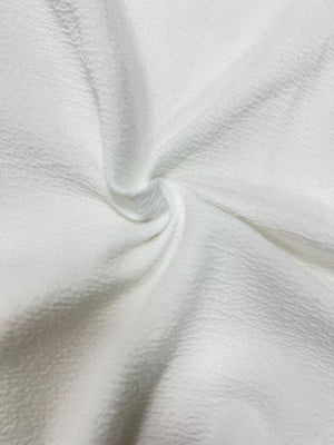 White textured fabric detail of a longline vest coat