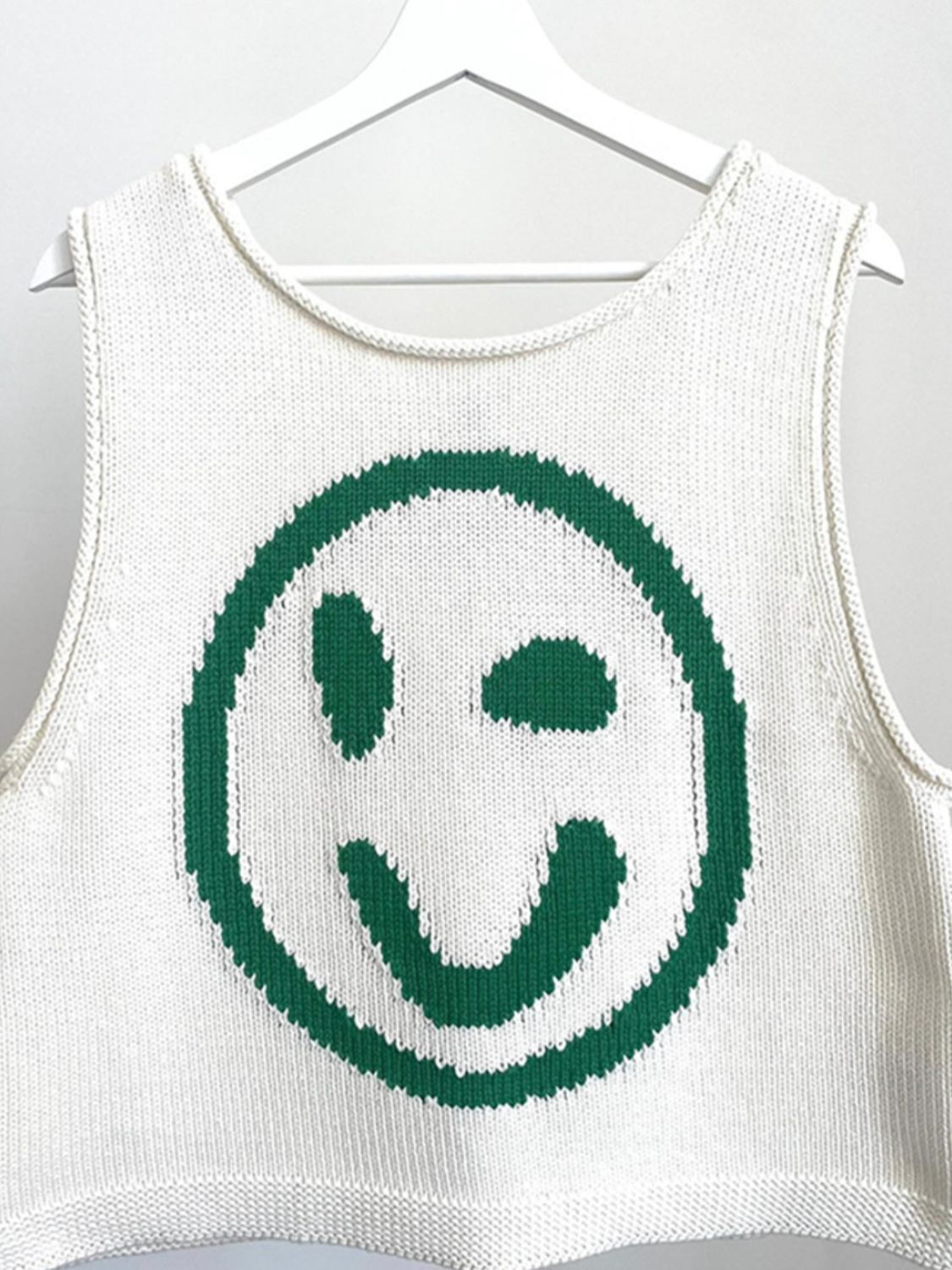 White knit tank top with green smiley face graphic