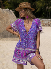 Purple floral print V-neck romper with tie detail and short sleeves.